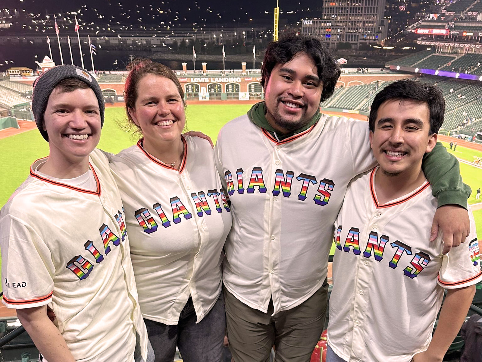 group of four coastpriders at a giants came. they are all wearing the giants pride jerseys