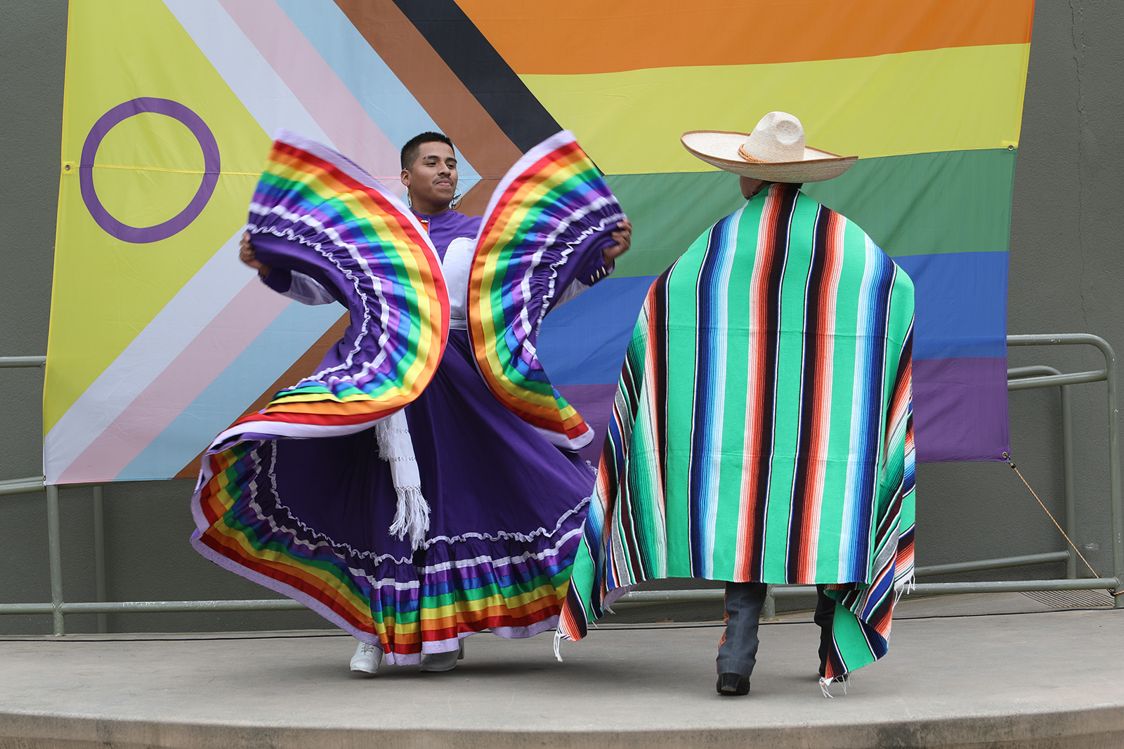 folclorico dancers in traditional costumes in pride colors